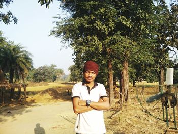 Portrait of man with arms crossed standing on field 