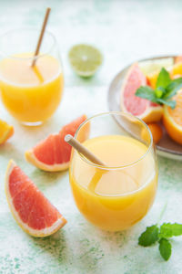 Glass of juice and fresh citrus fruits