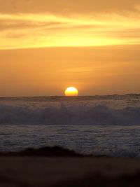 Scenic view of sea against orange sky