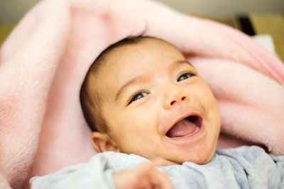 Portrait of cute baby girl lying on bed