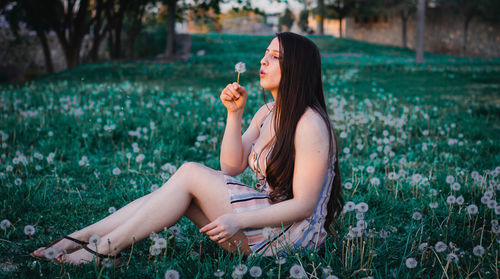 Midsection of woman sitting on field