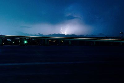 Illuminated bridge against sky at night