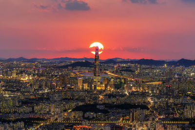 Illuminated buildings against sky during sunset