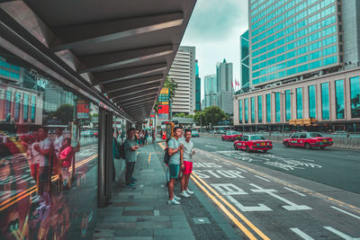 People walking on city street amidst buildings