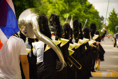 People wearing costumes in parade walking on street in city