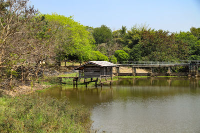 House by lake against sky