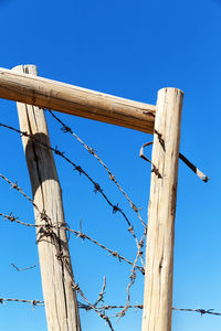 Low angle view of barbed wire against clear sky