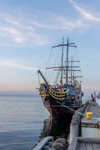 Sailboat moored in sea against sky