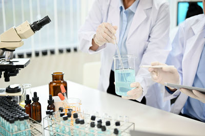 Midsection of scientist working in laboratory