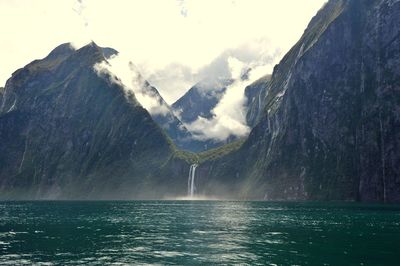 Scenic view of lake in front of mountains against sky