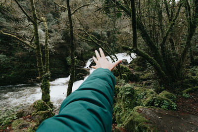 Low section of person on rock in forest