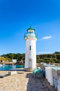 Lighthouse by sea against sky