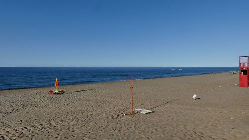 Scenic view of beach against clear blue sky