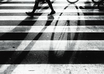 Low section of person walking on zebra crossing