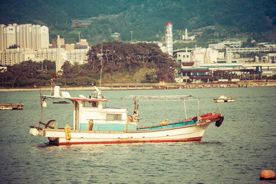 Sailboats in sea by buildings in city