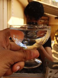 Close-up of hand holding glass of water