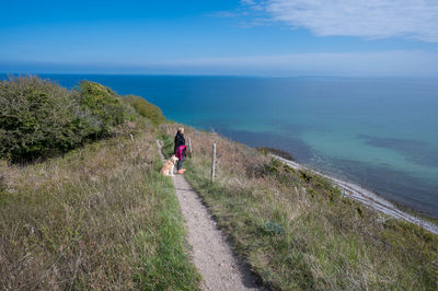 Lady and dog walking the geological site jernhatten in mols bjerge nationalpark