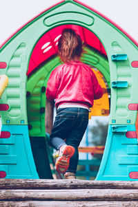 Rear view of girl walking in play equipment