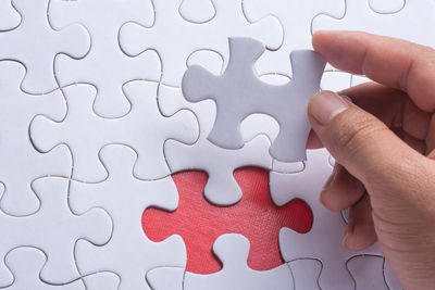 Close-up of human hand holding puzzle piece