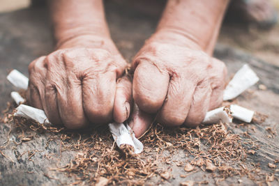 Cropped image of hands crushing cigarettes