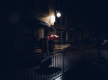 People walking on wet street at night