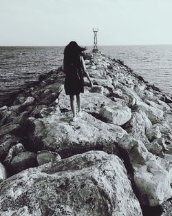 Rear view of woman standing on beach