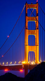 View of suspension bridge against blue sky