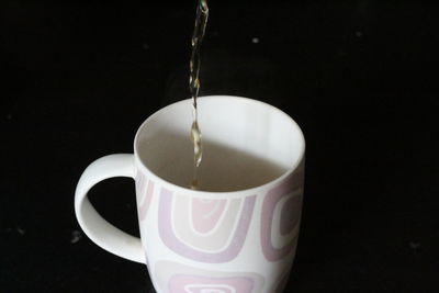 Close-up of coffee cup over black background