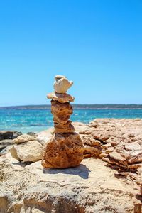 Stack of rocks on beach against clear sky