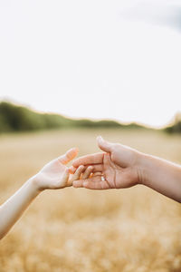 Cropped hand of woman against sky