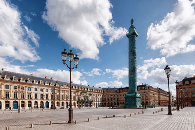 Buildings in town against cloudy sky