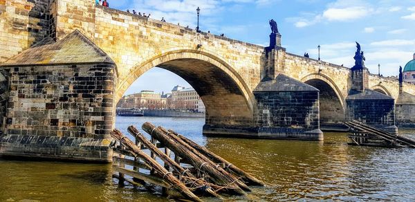 Arch bridge over river against sky