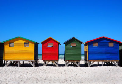 Beach huts against clear blue sky