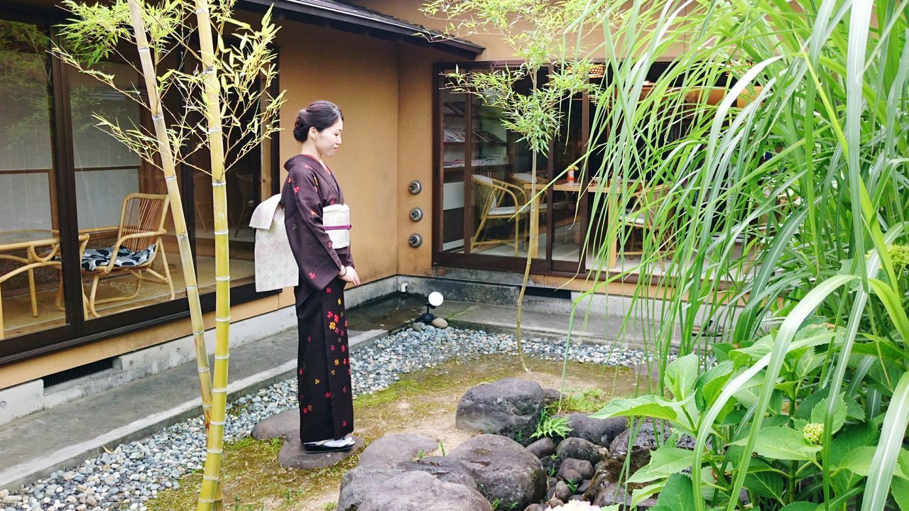 real people, full length, one person, architecture, rock - object, standing, lifestyles, building exterior, outdoors, built structure, walking, leisure activity, day, plant, casual clothing, water, beauty in nature, kimono, nature, tree, vacations, young adult, young women, people