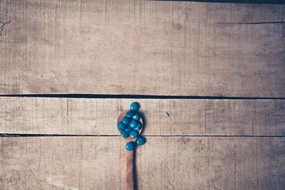 Close-up of blue candies in spoon on wooden table