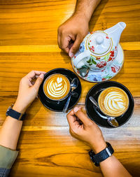 Low section of woman holding coffee cup on table