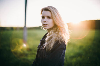 Portrait of woman standing on field against sky