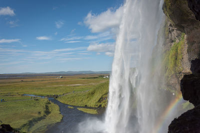 Scenic view of waterfall against sky