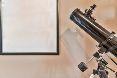Close-up of telescope against wall