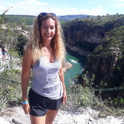 Portrait of smiling young woman standing on rock