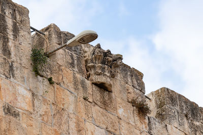 Low angle view of stone wall against sky