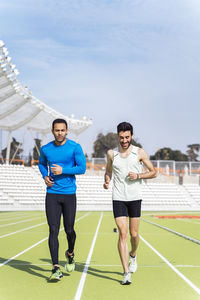 Male athletes running on sports track