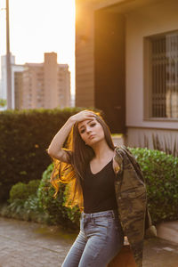 Portrait of young woman leaning against fire hydrant 