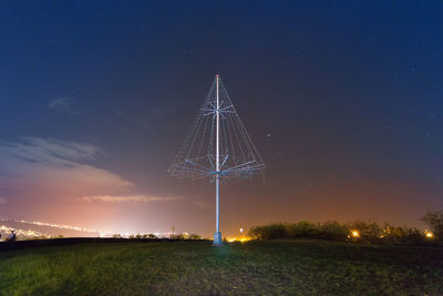 Scenic view of illuminated field against sky at night