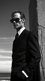 Portrait of young man standing against wall