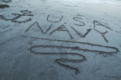 High angle view of text on sand at beach