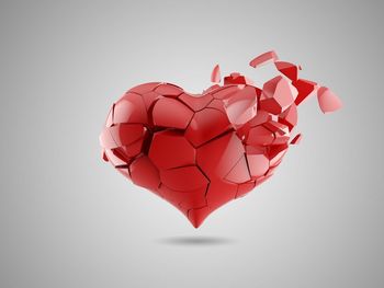 Close-up of red heart shape over white background