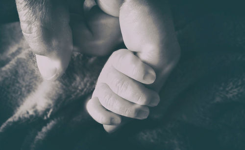 Close-up of baby hand on bed