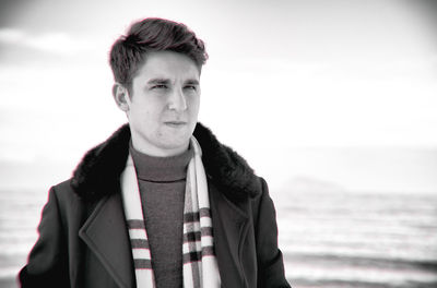 Portrait of young man standing against sea