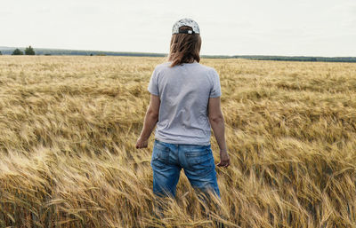 Rear view of woman standing on field